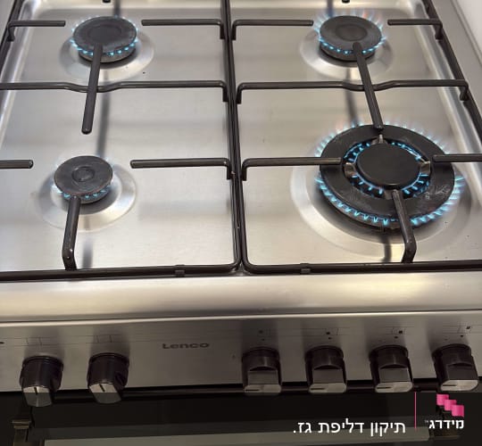 כיריים גז עם ארבעה מבערים דולקים במטבח מודרני